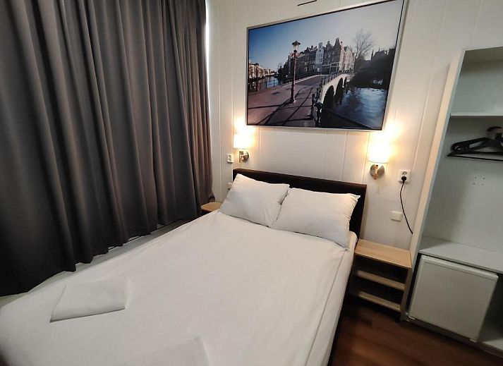 Ruime kamer in Hotel Holland Lodge Utrecht met grote ramen en sfeervolle verlichting.