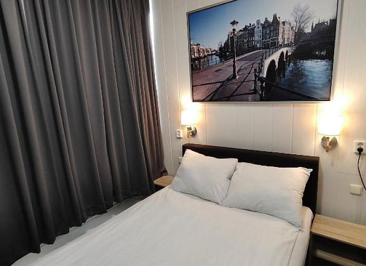 Ruime kamer in Hotel Holland Lodge Utrecht met grote ramen en sfeervolle verlichting.