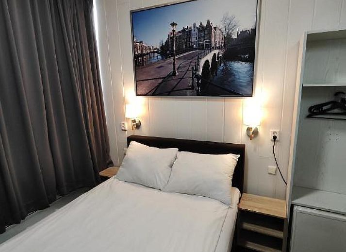 Ruime kamer in Hotel Holland Lodge Utrecht met grote ramen en sfeervolle verlichting.