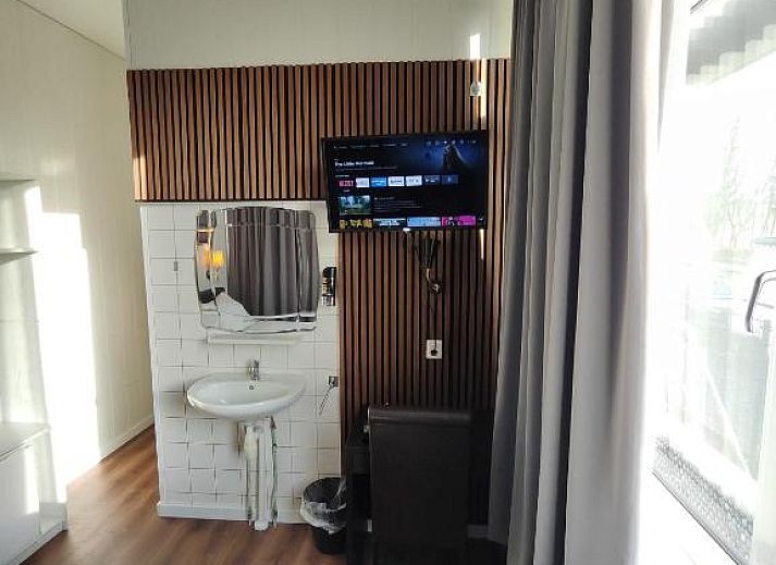 Stijlvolle televisiehoek in Hotel Holland Lodge, Utrecht met moderne faciliteiten.