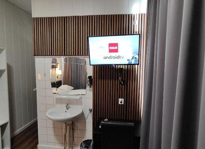 Gezellige slaapkamer in Hotel Holland Lodge Utrecht met uitzicht op de stad.