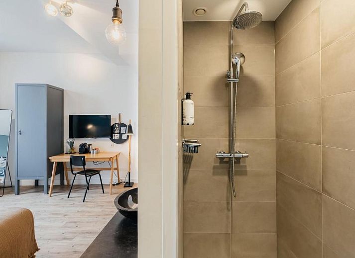 Sfeervolle slaapkamer in Eye Hotel Utrecht met kunst aan de muur en groot raam met uitzicht.