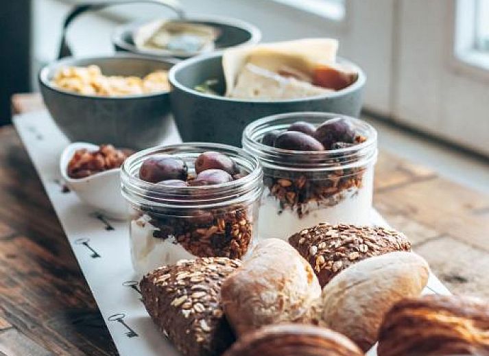 Sfeervolle slaapkamer in Eye Hotel Utrecht met kunst aan de muur en groot raam met uitzicht.