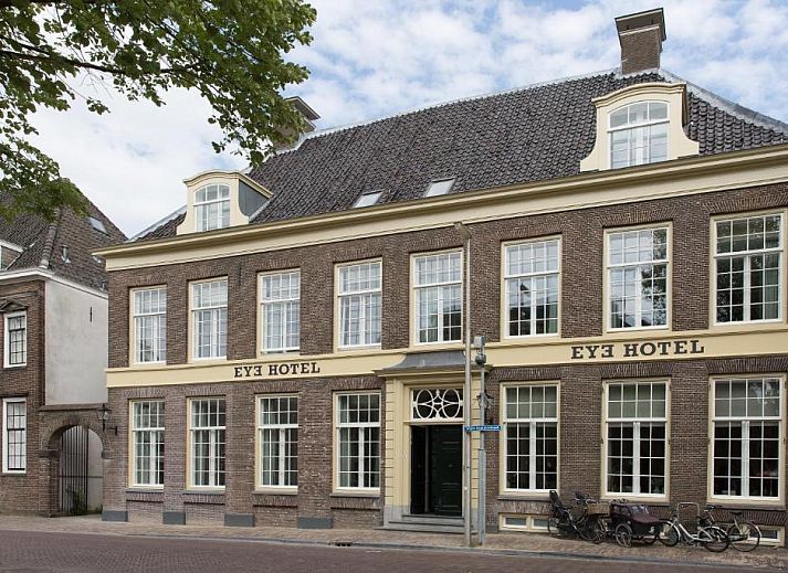 Sfeervolle slaapkamer in Eye Hotel Utrecht met kunst aan de muur en groot raam met uitzicht.