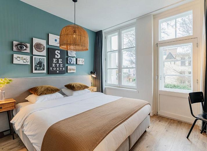 Knusse slaapkamer onder houten balken in Eye Hotel vakantiehuis Utrecht.