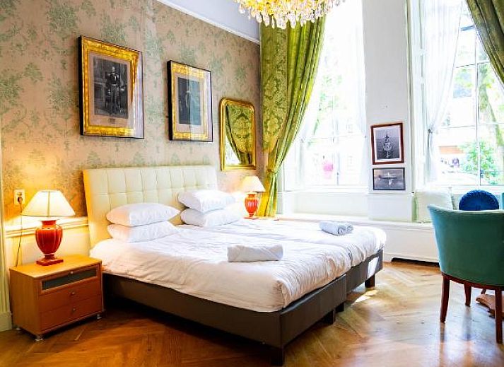 Ruime slaapkamer in Hotel Museumkwartier Utrecht, vakantie appartement met houten balken en gezellige sfeer.