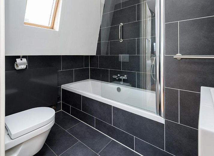 Ruime slaapkamer in Hotel Museumkwartier Utrecht, vakantie appartement met houten balken en gezellige sfeer.