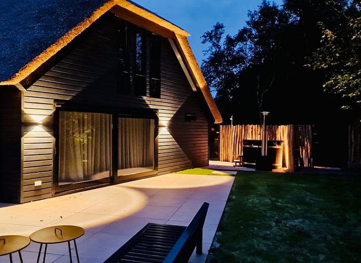 Gemuetliches Esszimmer im Ferienhaus in Ballum, Ameland, mit Blick auf den gruenen Garten, ideal fuer Familienessen.