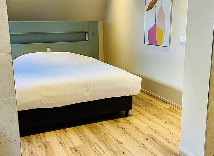 Gemuetliches Esszimmer im Ferienhaus in Ballum, Ameland, mit Blick auf den gruenen Garten, ideal fuer Familienessen.