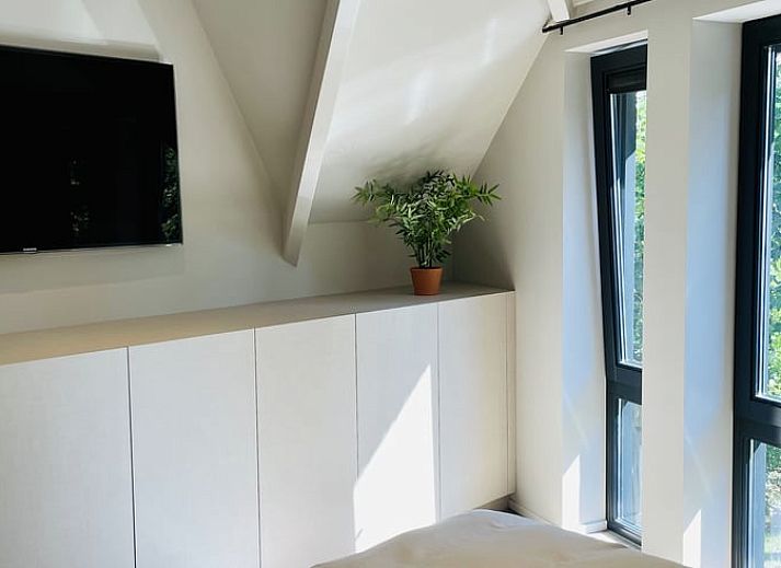 Gemuetliches Esszimmer im Ferienhaus in Ballum, Ameland, mit Blick auf den gruenen Garten, ideal fuer Familienessen.