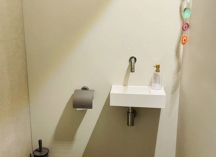 Aussenlounge im Ferienhaus in Ballum, Ameland, mit bequemen Sitzgelegenheiten und gruener Umgebung, ideal zum Entspannen.