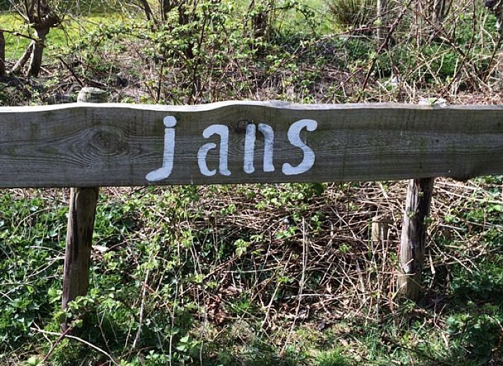 Cozy living room in Jans vacation home, Ballum, Ameland, with fireplace and wooden beams.