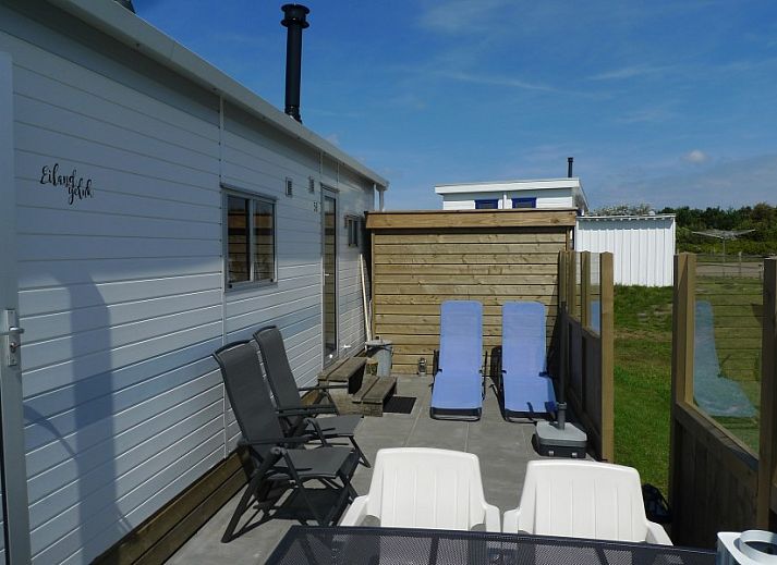 Island happiness chalet in Ballum, Ameland with sunny veranda and wooden terrace, ideal for relaxation on the Wadden Islands.