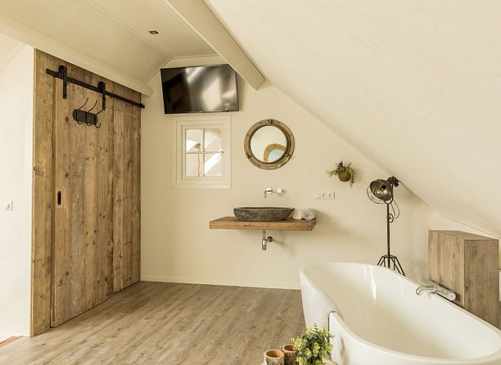 Geraeumiger Garten im Ferienhaus Chill op Ameland in Ballum mit Liegestuehlen und Terrasse.