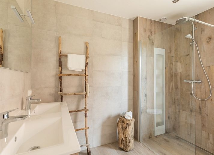 Geraeumiger Garten im Ferienhaus Chill op Ameland in Ballum mit Liegestuehlen und Terrasse.