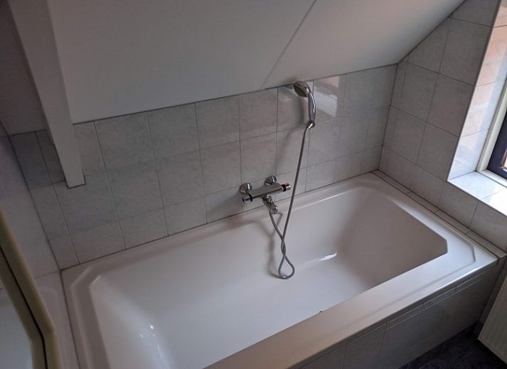 Vakantiehuis Kobbedunen in Ballum, Ameland met rode dakpannen en groene omgeving, ideaal voor een ontspannen verblijf op de Waddeneilanden.