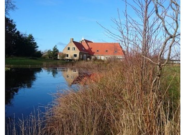 Vakantiehuis Kobbedunen in Ballum, Ameland met rode dakpannen en groene omgeving, ideaal voor een ontspannen verblijf op de Waddeneilanden.