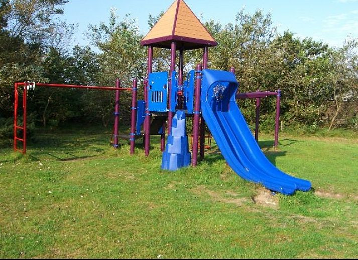 Gezellige eetruimte in vakantiehuis Kobbedunen, Ballum, Ameland met houten tafel en bankjes, ideaal voor familiediners op de Waddeneilanden.