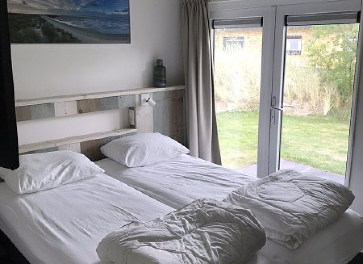 Geniessen Sie die sonnige Terrasse des Bungalows Mistral in Ballum, Ameland, mit bequemen Sitzgelegenheiten und Blick auf die Natur des Wattenmeeres.