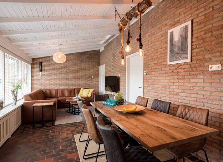 Veranda van vakantiehuis Artemis in Ballum, Ameland met een stijlvol wit houten terras en zonnebloemen.