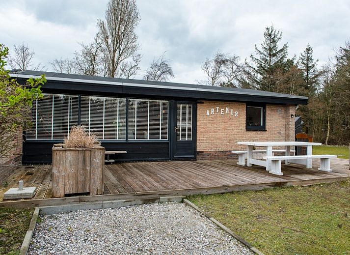 Gezellig terras bij Artemis vakantiehuis in Ballum, Ameland met comfortabele loungebanken en parasol.