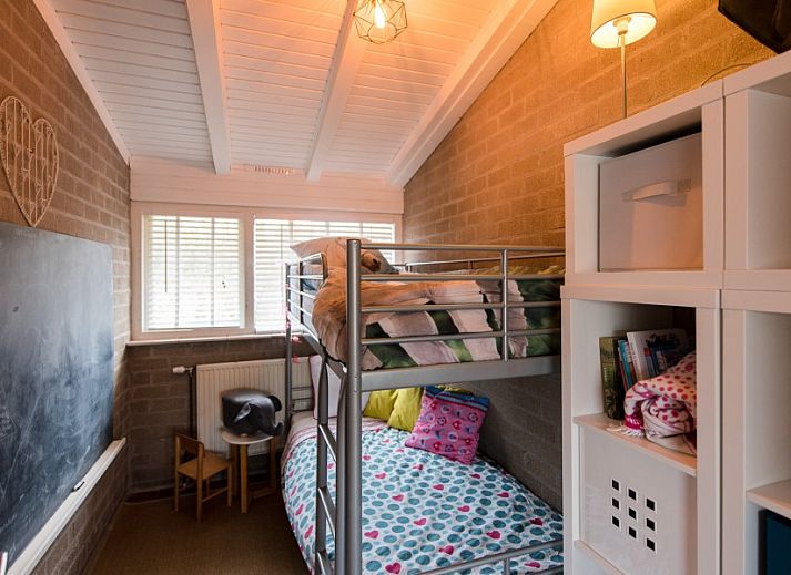 Detail van het terras bij Artemis vakantiehuis in Ballum, Ameland met een vaas zonnebloemen en decoratieve elementen.