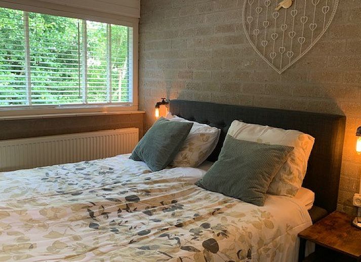 Detail van het terras bij Artemis vakantiehuis in Ballum, Ameland met een vaas zonnebloemen en decoratieve elementen.