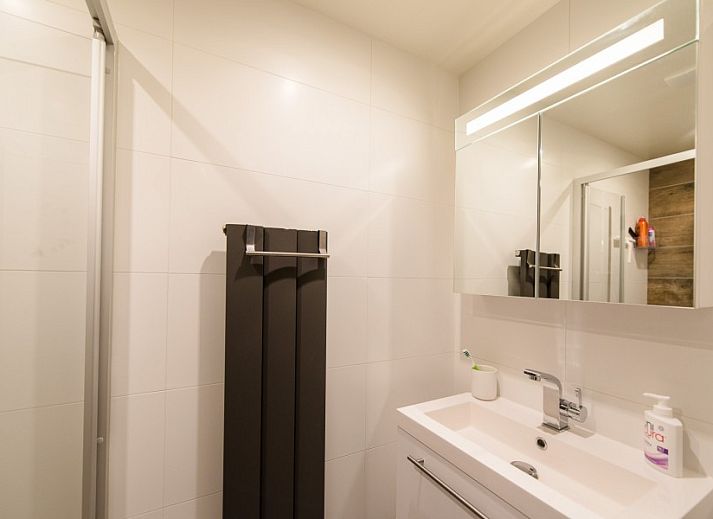 Sfeervolle woonkamer van vakantiehuis Artemis in Ballum, Ameland met een hoekbank en veel natuurlijk licht.