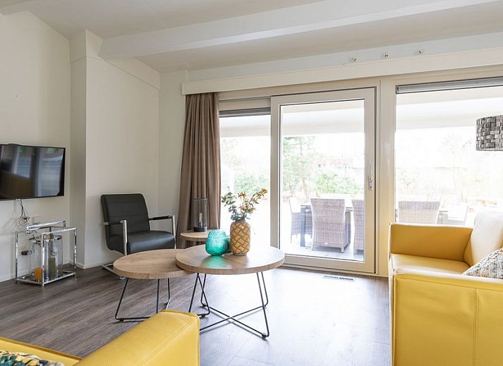 Terrasse des Ferienhauses Duinroos in Ballum, Ameland, mit Picknicktisch und Liegestuehlen im Garten.