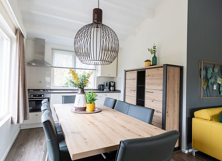 Terrasse des Ferienhauses Duinroos in Ballum, Ameland, mit Picknicktisch und Liegestuehlen im Garten.