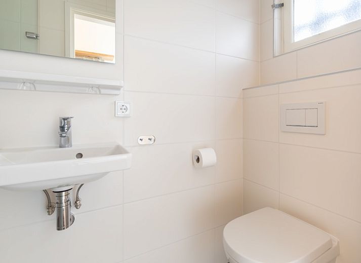 Umgebung von Vakantiewoning Duinroos, Ballum, Ameland, mit nahen Duenen und dem Meer in der Ferne.