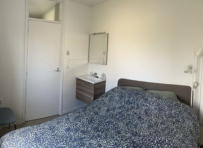 Houten eettafel op het terras van Zeevonk vakantiehuis in Ballum, Ameland, met uitzicht op de groene omgeving.