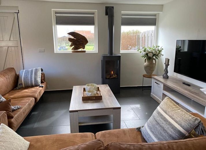 Gemuetliches Wohnzimmer in Tree Lodge, Ballum, Ameland mit bequemer Sitzecke und Kamin.