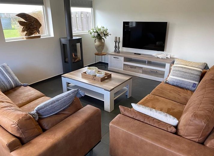 Gemuetliches Wohnzimmer in Tree Lodge, Ballum, Ameland mit bequemer Sitzecke und Kamin.