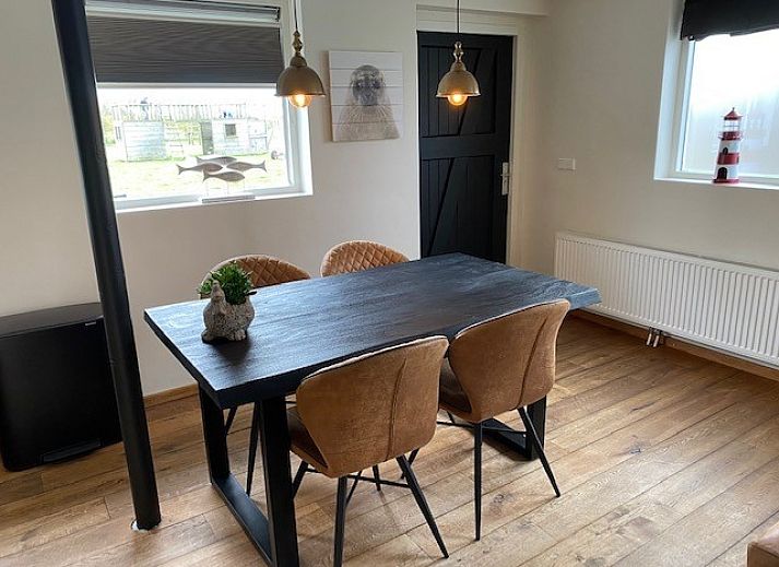 Stijlvolle woonkamer in Appartement Fleurie, Ballum, Ameland met comfortabele leren banken en houten vloeren.