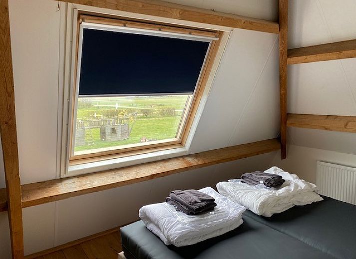 Moderne eetkamer en keuken in Appartement Fleurie, Ballum, Ameland met houten meubels en sfeervolle verlichting.