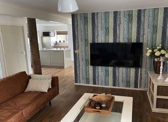 Gemuetliche Sitzecke in der Lodge 't Pandje, Ballum, Ameland mit Blick auf die Natur durch grosse Fenster.