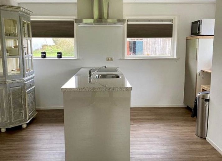 Gemuetliche Sitzecke in der Lodge 't Pandje, Ballum, Ameland mit Blick auf die Natur durch grosse Fenster.