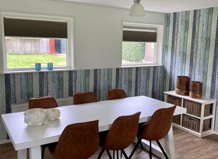 Gemuetliche Sitzecke in der Lodge 't Pandje, Ballum, Ameland mit Blick auf die Natur durch grosse Fenster.