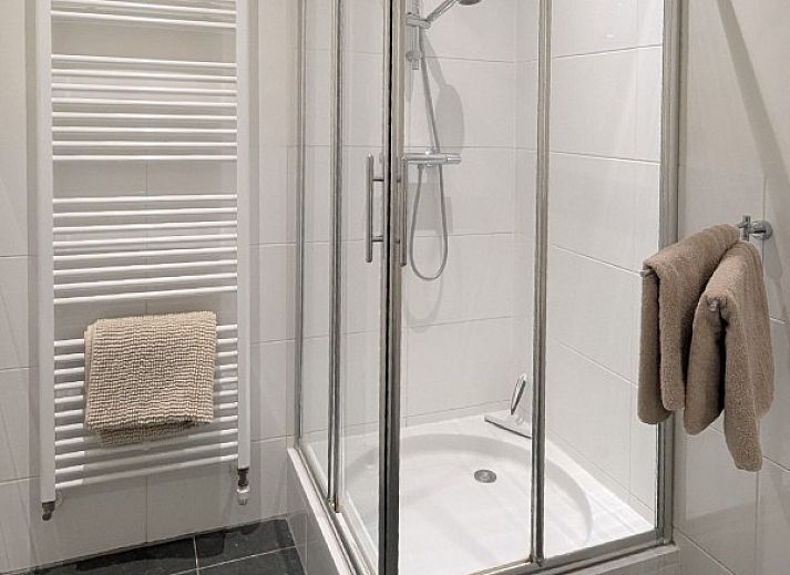 Modernes Wohnzimmer einer kleinen Wohnung in Ballum, Ameland, mit stilvoller Einrichtung und Blick auf die Natur.