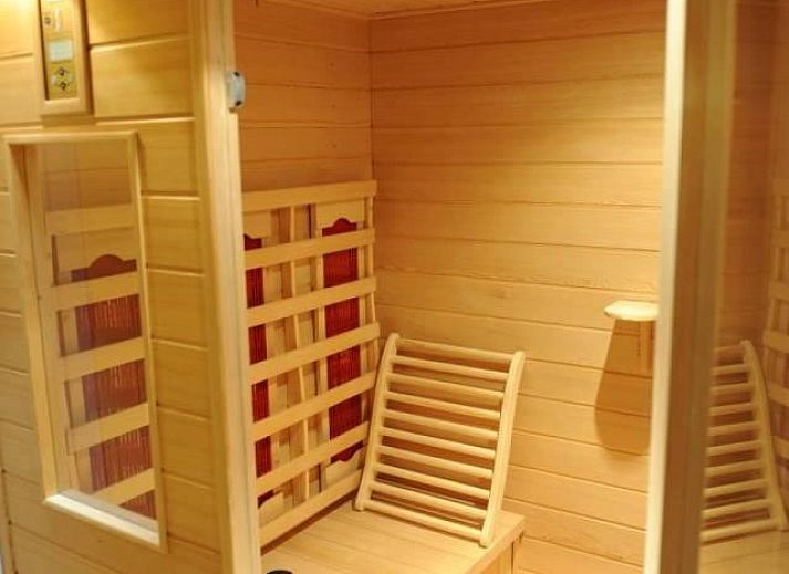 Gemuetliches Interieur des Ahorn-Ferienhauses in Ballum, Ameland, Watteninseln mit geraeumiger Sitzecke.