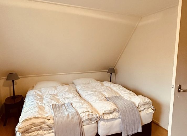 Gemuetliche Vorderseite des Ferienhauses Akkerduin in Ballum, Ameland, mit grossen Fenstern und bluehenden Hortensien auf den Watteninseln.