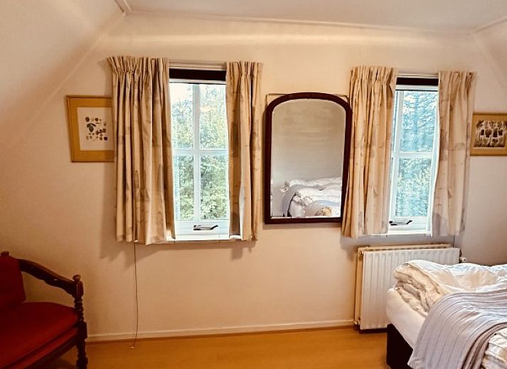 Gemuetliche Vorderseite des Ferienhauses Akkerduin in Ballum, Ameland, mit grossen Fenstern und bluehenden Hortensien auf den Watteninseln.