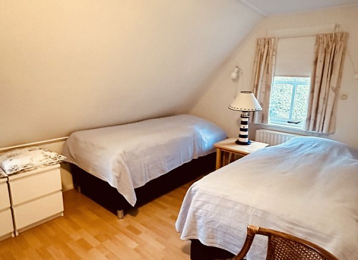 Gemuetliche Vorderseite des Ferienhauses Akkerduin in Ballum, Ameland, mit grossen Fenstern und bluehenden Hortensien auf den Watteninseln.