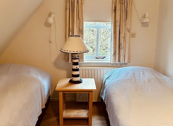 Gemuetliche Vorderseite des Ferienhauses Akkerduin in Ballum, Ameland, mit grossen Fenstern und bluehenden Hortensien auf den Watteninseln.