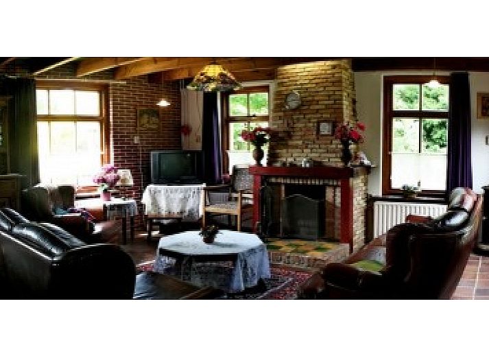 Vacation home Suzan in Ballum, Ameland with charming facade and red gate, surrounded by nature on the Wadden Islands.