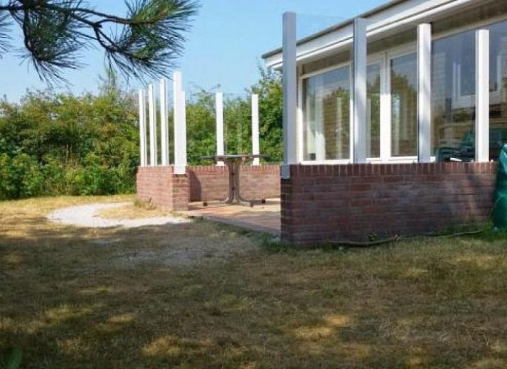 Bungalow Jan Dorus in Buren, Ameland met zonnige veranda en groene tuin.