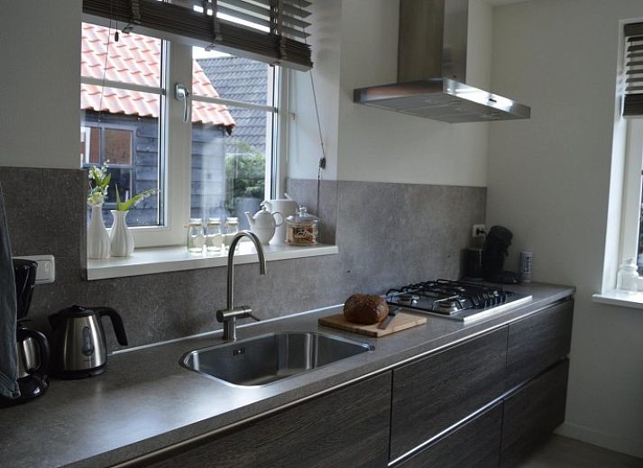 Gezellige woonkamer in vakantiehuis Waddengoud, Buren, Ameland met moderne inrichting en comfortabele zithoek.