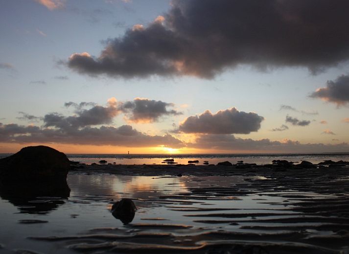 Slaapkamer in Waddengoud vakantiehuis, Buren, Ameland met comfortabel bed en praktische opbergruimte.