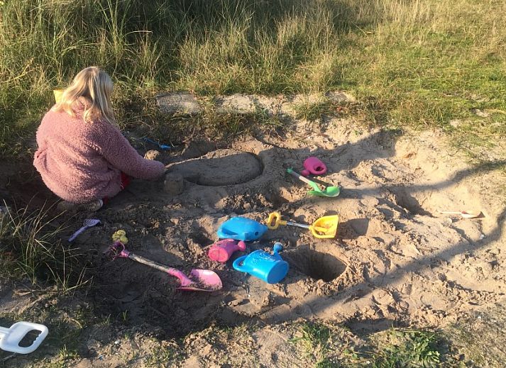 Gezellige woonkamer van Wellnessvilla Zee & Zo vakantiehuis in Buren, Ameland met comfortabele zithoek.